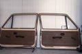 2 dismantled doors from an old car stand on a wall in a workshop Royalty Free Stock Photo