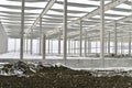 A dismantled plant hall in winter. Building site during winter. The concept of the end of the building season and the end of