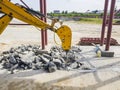 Dismantling of reinforced concrete with an excavator using a hydraulic hammer. Rigging of reinforced concrete using heavy