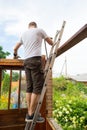 Dismantling the roof. The worker removes old boards Royalty Free Stock Photo