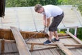 Dismantling the roof. The worker removes old boards Royalty Free Stock Photo