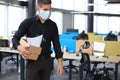 Dismissal employee in an epidemic coronavirus. Dismissed worker going from the office with his office supplies