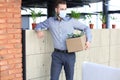 Dismissal employee in an epidemic coronavirus. Dismissed worker going from the office with his office supplies