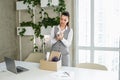 Dismissal. Fired frustrated employee woman packing belongings in cardboard box leaving workplace Royalty Free Stock Photo