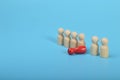 Dismissal, layoff, unemployment, employment stress. Red wooden figure overturns row group of workers