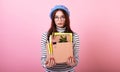 Dismissed female student lady in a stylish beret hat, with a cardboard box in her hands on a pink background Royalty Free Stock Photo