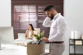 Dismissed man packing personal stuff into box in office Royalty Free Stock Photo