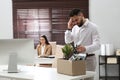 Dismissed man packing personal stuff into box in office Royalty Free Stock Photo