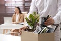 Dismissed man packing personal stuff into box in office, closeup Royalty Free Stock Photo