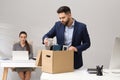 Dismissed man packing personal stuff into box in office Royalty Free Stock Photo