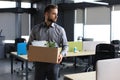 Dismissed worker going from the office with his office supplies Royalty Free Stock Photo