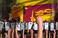 disorder stopping concept - protest in Sri Lanka on flag background, police officers stand against the protesting crowd -