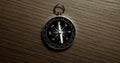 Disorientated spinning compass against wooden background closeup footage