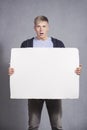 Disoriented man holding white empty panel.