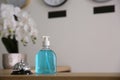 Dispenser bottle of antiseptic gel and service bell on reception desk in hotel. Space for text Royalty Free Stock Photo