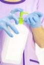 Dispenser with disinfectant. gloved hands. use of a disinfectant in medicine,