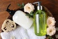 Dispensers of liquid soap, towel and roses in wicker basket on wooden table, top view Royalty Free Stock Photo