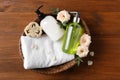 Dispensers of liquid soap, towel and roses in wicker basket on wooden table Royalty Free Stock Photo