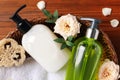 Dispensers of liquid soap, towel and roses in wicker basket on wooden table, top view Royalty Free Stock Photo