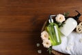 Dispensers of liquid soap, towel and roses in wicker basket on wooden table, top view. Space for text Royalty Free Stock Photo