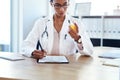 Dispensing drugs right from the doctors room. a young doctor filling out a form for a prescription in her consulting