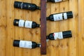 Display of Alentejo wine bottles on wall-mounted rack in a rustic restaurant.