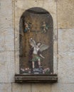 Display featuring the archangel Saint Michael vanquishing Satan on the wall of a church in Alfama.