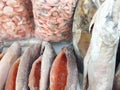 A display of frozen red fish and seafood in a grocery store. Market square, fresh salmon and king prawns in clear plastic bags. Royalty Free Stock Photo