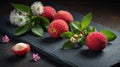 Fresh Lychees on Dark Slate with Flowers and Mint Leaves Royalty Free Stock Photo