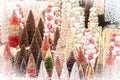 Display of pastel and brown bottle brush and pompom Christmas trees with glitter and lots of pink