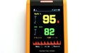 Display of the pulse oximeter showing blood oxygen ninety-five in yellow and pulse eighty-two in green.. Royalty Free Stock Photo