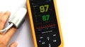Display of the pulse oximeter showing blood oxygen ninety-seven in yellow and pulse eighty-seven in green.