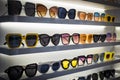 Display rack full of sunglasses. Stand with sunglasses. Fashionable Trendy sunglasses, Summer eyeglasses on the shop Royalty Free Stock Photo