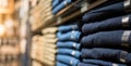 Display shelves with denim pants jeans trousers in clothing on the rack in department clothes of retail store