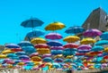 Display of umbrellas, floating towards a blue sky, in a conceptual tourism concept Royalty Free Stock Photo