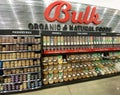 A display of a variety of bulk nuts, granola, trail mix, honey, and nut butters at a grocery store
