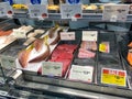 A display of a variety of fish in a refrigerated case at a grocery store