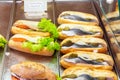 Display window show case of a bakery and pastry shop with assortment of healthy fast food sandwiches with salmon herring