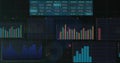 Displaying dark analytics dashboard on screen, showing cyan table, bar charts, area chart, grid Royalty Free Stock Photo