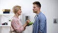 Displeased adult man refusing mother feeding from spoon, overprotection problem Royalty Free Stock Photo