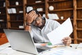 stressed black male employee reading a document bank statement