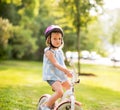 Displeased baby girl with bicycle in park Royalty Free Stock Photo