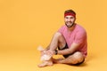 Displeased bearded fitness sporty guy sportsman in headband t-shirt in home gym isolated on yellow background. Workout Royalty Free Stock Photo