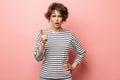 Displeased beautiful woman posing isolated over pink wall background make stop gesture