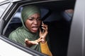 Displeased Black Muslim Woman Talking On Cellphone On Backseat In Car Royalty Free Stock Photo