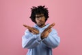 Displeased black teenager gesturing STOP, expressing his disagreement on pink studio background Royalty Free Stock Photo