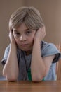 Displeased boy sitting at table Royalty Free Stock Photo