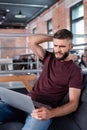 Displeased businessman sitting on sofa and