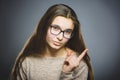 Displeased and contemptuous girl with threatens finger on gray background Royalty Free Stock Photo