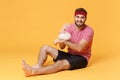 Displeased fitness sporty guy 20s sportsman in headband t-shirt in home gym isolated on yellow background. Workout sport